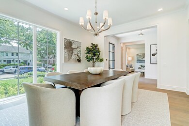 Formal dining features incredible floor to ceiling windows that overlook the front garden, Ruhlmann chandelier, and custom builtins. The dining room is perfect for entertaining with convenient access to the butler's bar.