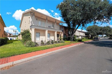 View of front of property with a front yard and a balcony