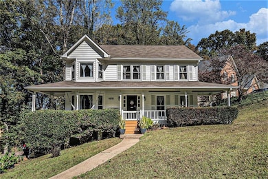 Farmhouse-style home featuring a large porch and a front yard