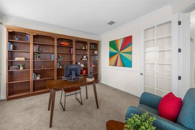 Carpeted office space with ornamental molding