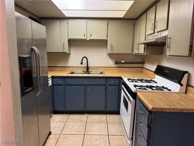 Kitchen with a sink, white range with gas cooktop,