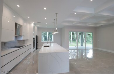 Kitchen featuring modern cabinets, a sink, white c