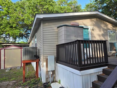 Back of house featuring central AC unit and a wooden deck
