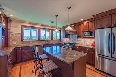 The kitchen is a dream with an island, granite counters, commercial grade stove, a breakfast nook, inlaid hardwood flooring.
