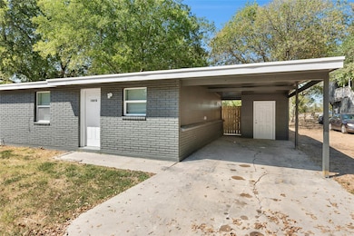 View of front of house with an attached carport, brick siding, and driveway