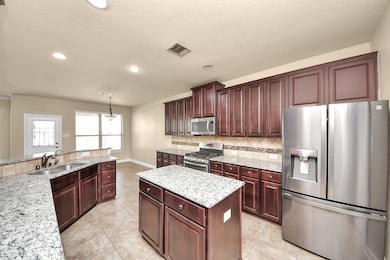 Spacious kitchen with dark wood cabinetry, granite