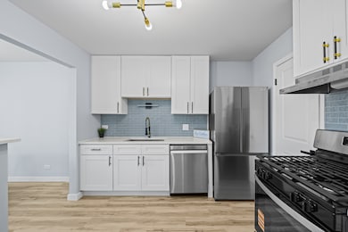 Bright, modern kitchen featuring white shaker cabi