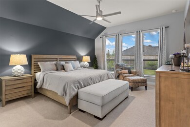 What a wonderful place to come home to, this stunning primary suite greets you with plush carpet, a warm custom paint, high ceiling, modern ceiling fan with lighting, large windows with blinds allowing in natural light brightening up this spacious primary bedroom, with extra space for a seating area.