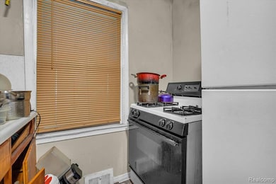 Kitchen featuring gas range and freestanding refrigerator