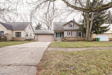 View of front of property featuring a front yard and a garage