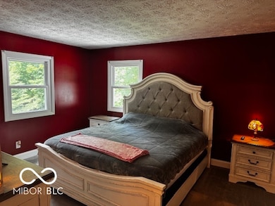 bedroom featuring multiple windows and a textured ceiling
