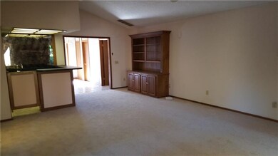 Living room has vaulted ceiling, built-in cabinets