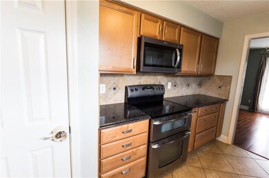 The kitchen has a double oven, tile backsplash, gr