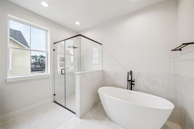 Luxurious primary bathroom featuring modern fixtur