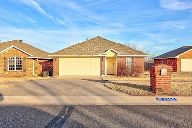 Single story home with driveway, brick siding, an attached garage, and roof with shingles