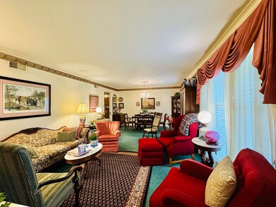 Carpeted living room with crown molding
