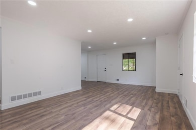 Spare room featuring wood finished floors, recessed lighting, crown molding, and baseboards