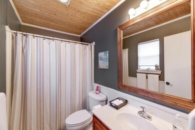 Full bathroom with ornamental molding, toilet, wo
