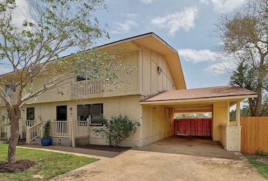 View of property featuring concrete driveway, a c