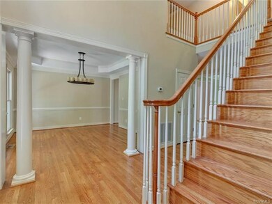 Two story foyer leads to formal dining room with t