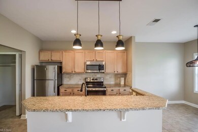 Kitchen with hanging light fixtures, backsplash, a