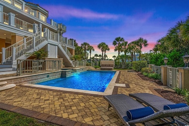 Pool at dusk with pool water feature and a patio a