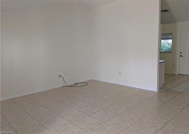 Spare room with light tile patterned flooring and baseboards