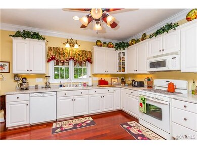 Spacious Kitchen, Crown Molding, Custom White Cabinetry, Corian Counter-tops, Gas Cooking, Wood Flooring