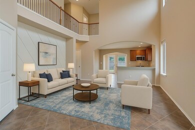 Living room with a towering ceiling, arched walkw