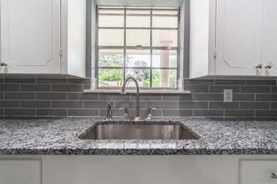 Kitchen featuring backsplash, stone counters, and 
