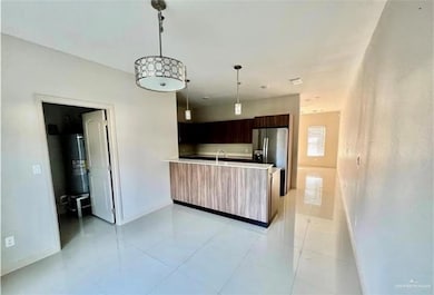 Kitchen with a peninsula, stainless steel fridge, baseboards, and modern cabinets