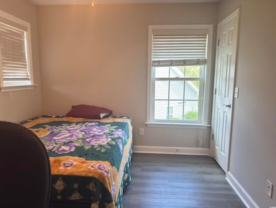 Bedroom with baseboards and wood finished floors
