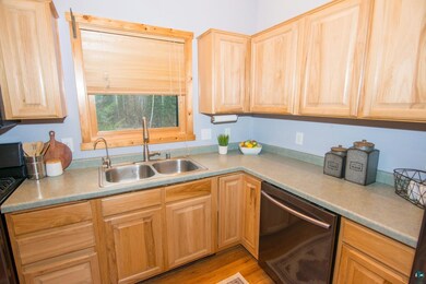 Kitchen with light brown cabinetry, stainless stee
