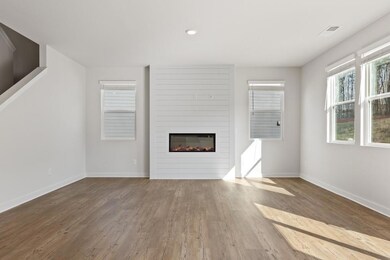 Unfurnished living room with a large fireplace, wood finished floors, and recessed lighting