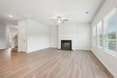 Unfurnished living room featuring ceiling fan and 