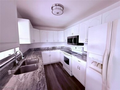 Kitchen featuring white appliances, white cabinetr
