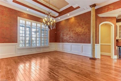 Hardwood flooring continues throughout as do Plantation Shutters.  Tray ceiling, heavy crown moldings, arched doorways and wainscoting. Faux finished walls are accented by recessed lighting.  This massive dining room is over 18' x 16!  Round, square, rectangle and oblongs all fit with plenty of seating.