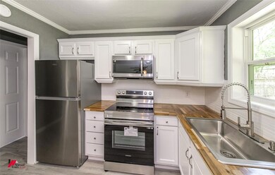 Kitchen featuring backsplash, wood counters, sink,