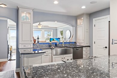 Kitchen featuring white cabinetry, dark stone coun