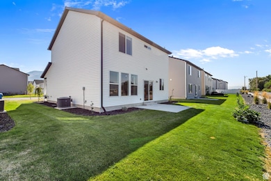 Back of property with a patio and a lawn