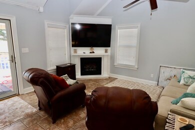 Living area with baseboards, a fireplace with rais