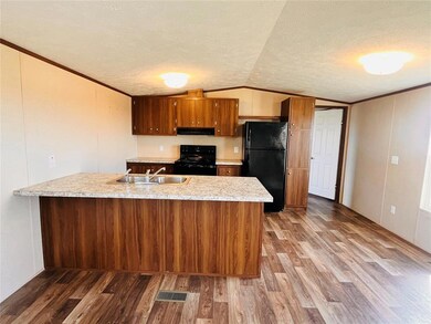 Kitchen featuring a textured ceiling, sink, lofted