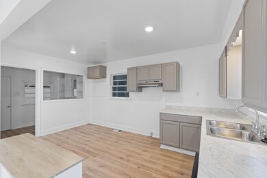 Kitchen featuring gray cabinets, sink, and light w