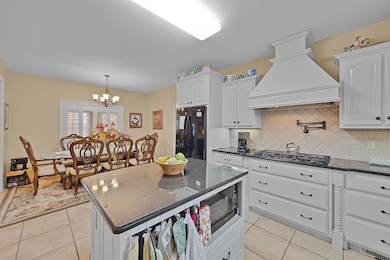 Kitchen with decorative backsplash, white cabinets