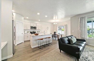 Living room with a chandelier, light wood finished floors, recessed lighting, and a textured ceiling