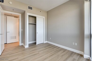 Unfurnished bedroom with baseboards, light wood-ty