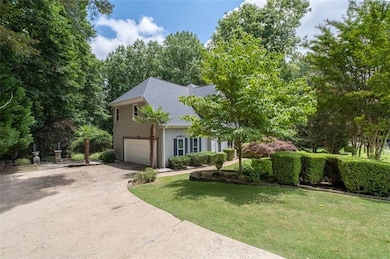 View of property hidden behind natural elements featuring stucco siding, concrete driveway, a front yard, a shingled roof, and an attached garage