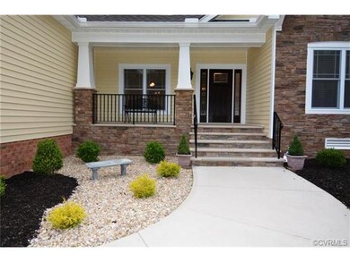 Stone steps and a concrete covered front porch.