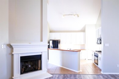Kitchen featuring rail lighting, white cabinetry, light tile floors, and black appliances
