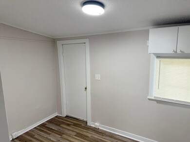 Unfurnished room featuring dark wood-type flooring, baseboards, and a textured ceiling